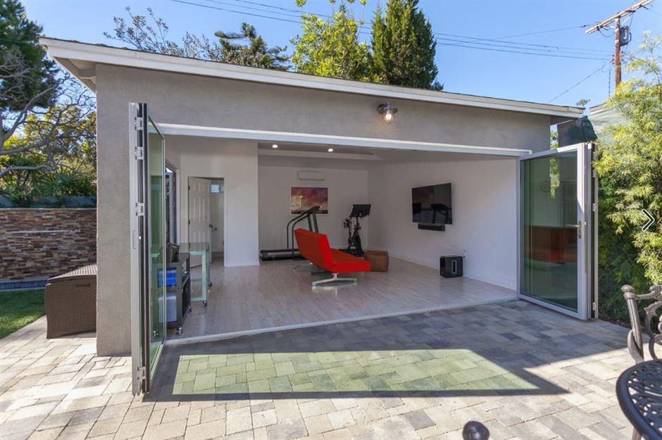 A garage converted into a light-filled home gym with folding glass doors